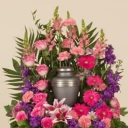 Pink and purple floral arrangement around a silver urn