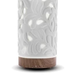 White carved diffuser with glowing cutout pattern and wood-look base