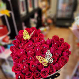 Heart-shaped bouquet of red roses with butterfly decorations