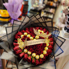 Bouquet of red roses with gold chocolates and a birthday ribbon