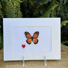 Cross-stitch card with an orange butterfly and small red heart