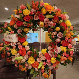 Large floral wreath with roses and lilies on a stand