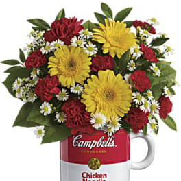 Bouquet of yellow daisies and red carnations in a Campbell's soup mug
