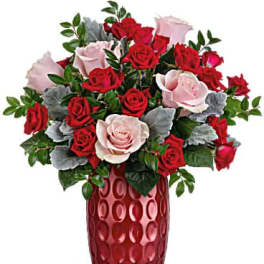 Red and pink roses arranged in a tall red vase