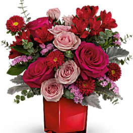 Pink and red rose bouquet in a red glass vase