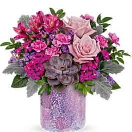 Pink and purple floral arrangement in a mosaic glass vase