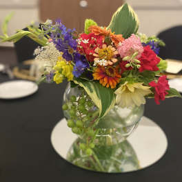 Colorful mixed bouquet in a clear glass vase on a table