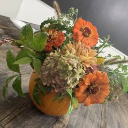 Orange flowers arranged in a pumpkin-shaped container