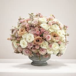 Large bouquet of pink and white roses in a gray vase