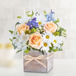 Peach roses and white daisies in a rustic wooden box