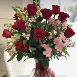 Bouquet of red roses and pink alstroemeria in a clear glass vase