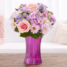 Pink and lavender mixed bouquet in a purple glass vase