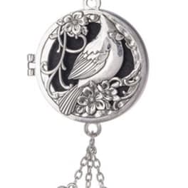 Round silver locket necklace with bird and flowers and dangling heart, flower, and crystal charms