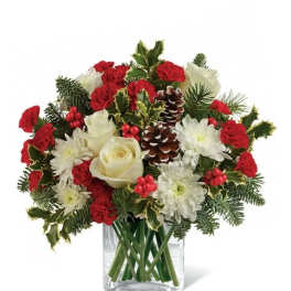 Holiday bouquet of red carnations, white roses, and chrysanthemums in a glass vase