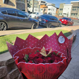 Bouquet of red roses wrapped in red paper with a ribbon
