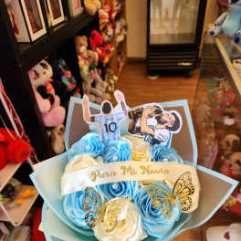 Blue and white rose bouquet with soccer player toppers and butterfly accents