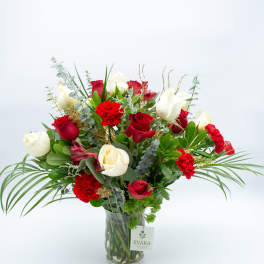 Red and white roses arranged in a clear glass vase