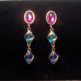 Pair of dangling earrings with pink and blue beads on a black background