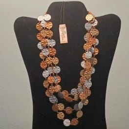 Layered coin necklace on a black display bust
