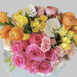 Bouquet of pink, yellow, orange, and white flowers on a round mirror
