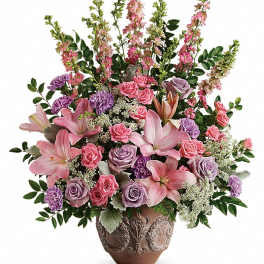 Tall pink and purple flower arrangement with lilies and roses in a decorative ceramic vase