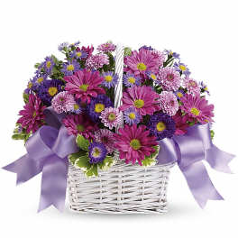Basket of purple and pink daisy-style flowers with lavender ribbon bows