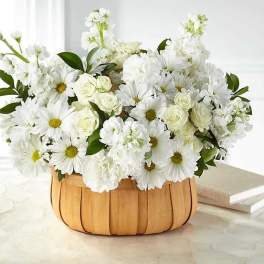 White daisies and roses arranged in a wooden basket