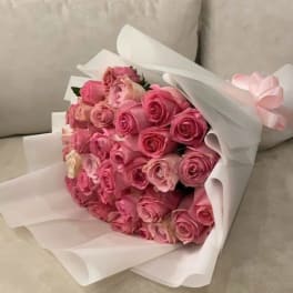 Bouquet of pink roses wrapped in white paper
