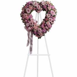 Heart-shaped pink and lavender rose wreath on a white standing easel
