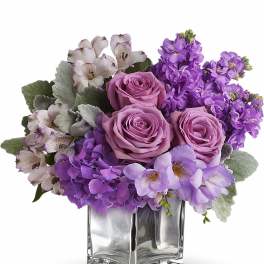 Short cube vase arrangement with lavender roses, purple hydrangea, and white alstroemeria