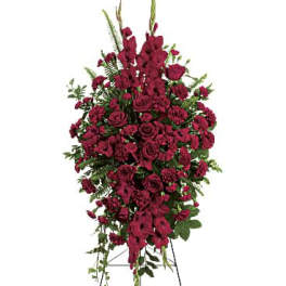 Tall standing spray of dark red roses and carnations on an easel