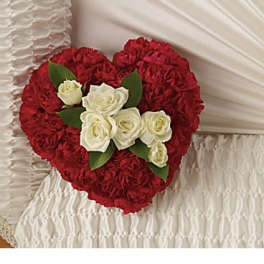 Heart-shaped red rose arrangement with white roses and green leaves