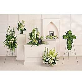 White and green floral funeral arrangements on stands and pedestals