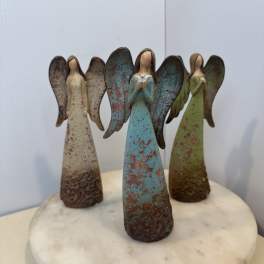 Three angel figurines standing on a round marble base