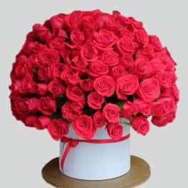 Large bouquet of red roses in a white hat box with a red ribbon