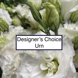 White flowers with green buds and a label reading Designer’s Choice Urn