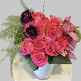 Pink and purple rose bouquet in a white vase