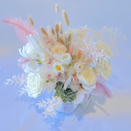 White floral arrangement with pink accents in a small vase