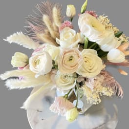 Cream and blush bouquet with roses and ranunculus in a vase