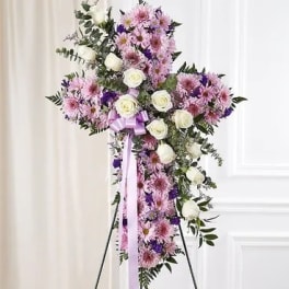 Standing floral cross with pink and white flowers on an easel
