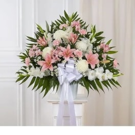 Standing floral spray with pink and white flowers and a white ribbon