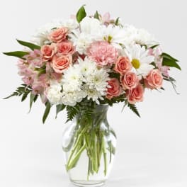 Pink roses and white daisies in a clear glass vase