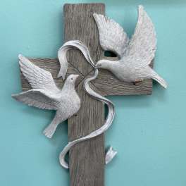 Wood-look cross wall plaque with two white doves and a flowing ribbon on a teal background