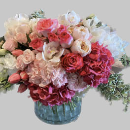 Pink and white floral arrangement in a blue glass vase