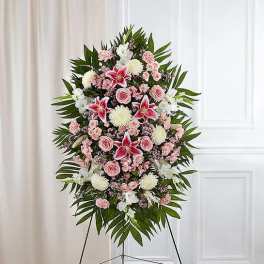 Standing floral spray with pink and white flowers on a black easel