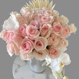 Bouquet of pale pink roses with white orchids in a vase