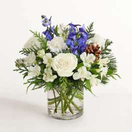 White and blue floral arrangement in a clear glass vase