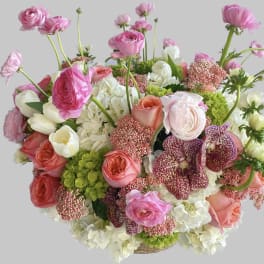 Pink and white mixed flower arrangement in a basket