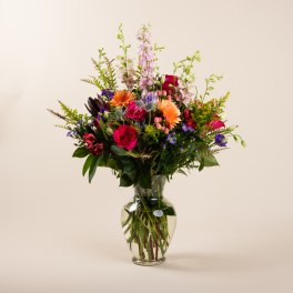 Mixed bouquet of colorful flowers in a clear glass vase