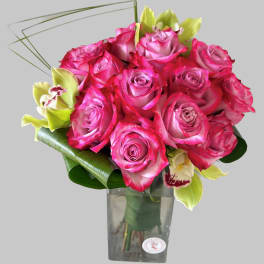 Pink roses and green orchids in a clear glass vase